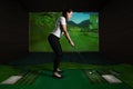 A girl playing screen golf. Golf Simulator. Royalty Free Stock Photo