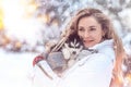 Girl playing with siberian husky in winter forest and park