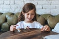 Girl playing with small figures sitting on soft Royalty Free Stock Photo