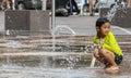 A girl playing among small fountains near Union Station in Denver on a very hot summer day