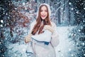 Girl playing with snow in park. women on mountain. Beautiful girl in the winter forest in white down jacket. Winter Royalty Free Stock Photo