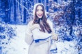 Girl playing with snow in park. women on mountain. Beautiful girl in the winter forest in white down jacket. Winter Royalty Free Stock Photo