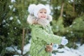 Girl playing snowballs. Funny little girl having fun in winter park. making snowballs happy child girl. winter girl throwing Royalty Free Stock Photo
