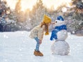 Girl playing with a snowman Royalty Free Stock Photo