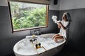 Girl playing with soap foam on bath by window Royalty Free Stock Photo