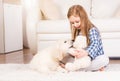 Girl playing with teddy bear and retriever puppy