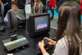 Girl playing with vintage Atari Pac Man at Games Week 2015 Royalty Free Stock Photo