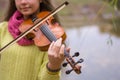 Girl playing the violin in the autumn park at a autumn foliage b Royalty Free Stock Photo