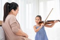 Girl playing violin with her pregnant mother for lullaby newborn in mother belly. Musical and entertainment concept Royalty Free Stock Photo