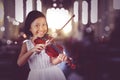 Girl playing violin while looking and smiling Royalty Free Stock Photo