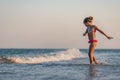 Girl playing with waves kicking and spinning under the summer sun enjoying the vacation Royalty Free Stock Photo