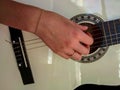 Girl playing on white classical guitar