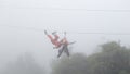 Girl playing zipline in the mist Royalty Free Stock Photo