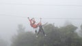 Girl playing zipline in the mist Royalty Free Stock Photo