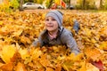 Girl plays in autumn foliage