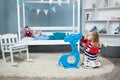 Girl plays with a blue piggy Bank Royalty Free Stock Photo