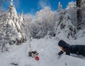 A girl plays with a corgi dog in a snowy forest. Sunlight. Winter`s tale