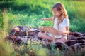 The girl plays with a ginger kitten on the street in the grass. Country girl playing with a cat