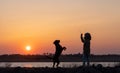 A girl plays with a guard dog of the Rottweiler breed against the backdrop of a lake and sunset Royalty Free Stock Photo