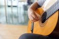 The girl plays the guitar. Hand on strings