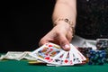 Girl plays poker in a casino, with chips, dollars, and wine. Concept of the gaming business. With space on a black background