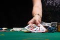 Girl plays poker in a casino, with chips, dollars, and wine. Concept of the gaming business. With space on a black background