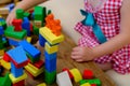 girl plays role-playing games with wooden figurines, figures, blocks, kindergarten games, concept of childhood, earlier child