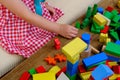 girl plays role-playing games with wooden figurines, figures, blocks, kindergarten games, concept of childhood, earlier child