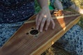 A girl plays a stringed old wooden instrument.