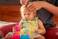 girl plays toy constructor father brushes her hair closeup Royalty Free Stock Photo