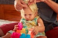 girl plays toy constructor father brushes her hair closeup Royalty Free Stock Photo