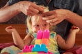 girl plays toy constructor father brushes her hair closeup Royalty Free Stock Photo