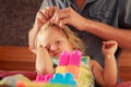 girl plays toy constructor father brushes her hair closeup Royalty Free Stock Photo