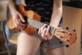 The girl plays on the ukulele. Lesson playing the guitar.