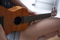 The girl plays on the ukulele. Lesson playing the guitar.