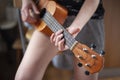 The girl plays on the ukulele. Lesson playing the guitar.