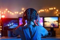 A girl plays video games at a computer. on the background of three monitors. Creative light Royalty Free Stock Photo