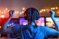 A girl plays video games at a computer. on the background of three monitors. Creative light Royalty Free Stock Photo