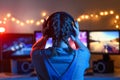 A girl plays video games at a computer. on the background of three monitors. Creative light Royalty Free Stock Photo