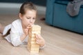 A girl plays with wooden tower blocks. a game for development. The concept of teaching children and their mental Royalty Free Stock Photo