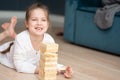 A girl plays with wooden tower blocks. a game for development. The concept of teaching children and their mental Royalty Free Stock Photo