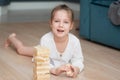A girl plays with wooden tower blocks. a game for development. The concept of teaching children and their mental Royalty Free Stock Photo