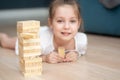 A girl plays with wooden tower blocks. a game for development. The concept of teaching children and their mental Royalty Free Stock Photo