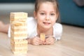 A girl plays with wooden tower blocks. a game for development. The concept of teaching children and their mental Royalty Free Stock Photo