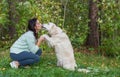 Girl pleasing a golden retriever dog in the park. Man`s best friend. Love for a pet Royalty Free Stock Photo