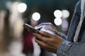 Girl pointing finger on screen smartphone on background illumination bokeh color light in night atmospheric city, hipster using Royalty Free Stock Photo