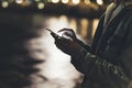 Girl pointing finger on screen smartphone on background illumination bokeh color light in night atmospheric city, hipster using Royalty Free Stock Photo