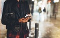 Girl pointing finger on screen smartphone on background illumination glow bokeh light in night atmospheric christmas city, hipster Royalty Free Stock Photo