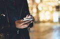 Girl pointing finger on screen smartphone on background illumination glow bokeh light in night atmospheric christmas city, hipster Royalty Free Stock Photo