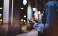 Girl pointing finger on screen smartphone on background illumination glow bokeh light in night atmospheric city, hipster using Royalty Free Stock Photo